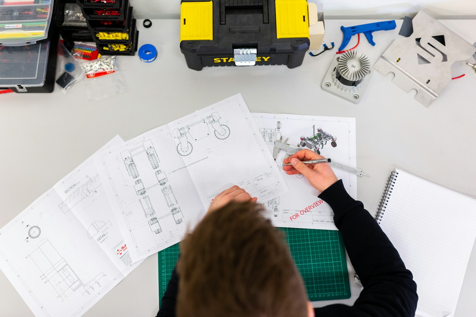 Mechanical engineer measuring components on manufacturing drawings